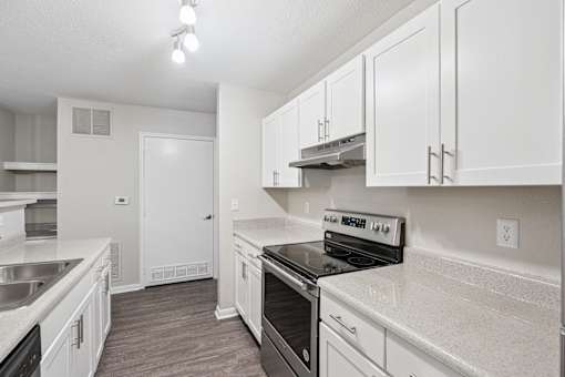 A kitchen with white cabinets and a black stove top oven.