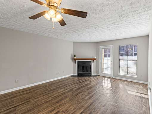Room with fireplace and ceiling fan at Stratford Village Montgomery AL