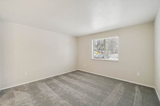 A room with a carpeted floor and a picture hanging on the wall.