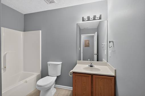 A white toilet sits next to a white sink in a bathroom.