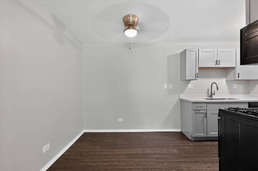Empty dining room with ceiling fan adjacent to the kitchen at Renaissance at Carol Stream in Carol Stream, IL.
