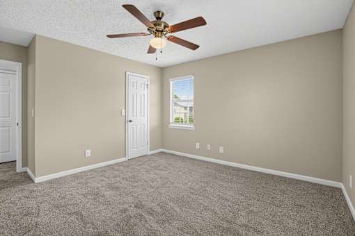Bedroom with a ceiling fan and carpeted floor at Arbours at Victoria Place in Prattville, AL