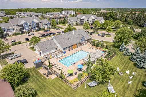 A large swimming pool surrounded by a wooden fence and lounge chairs.