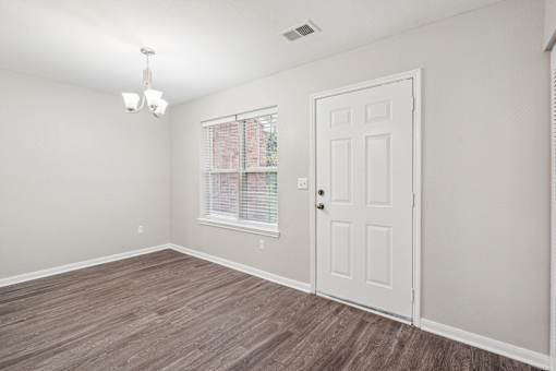 A room with a white door and a window with blinds.