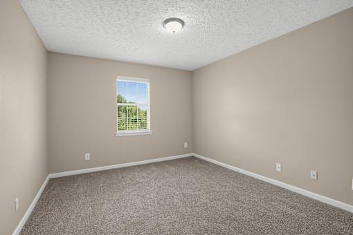Room with a window and carpeted floor at Arbours at Victoria Place in Prattville, AL
