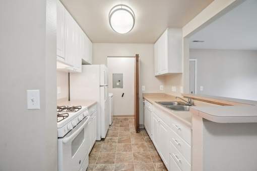 A kitchen with white appliances and cabinets.