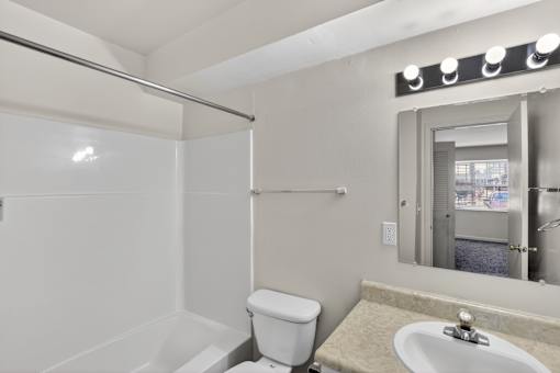 A white toilet sits next to a sink in a bathroom.