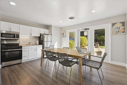 A modern kitchen with a dining table and chairs.
