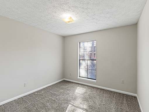 Bedroom with carpet and window at Stratford Village Montgomery AL