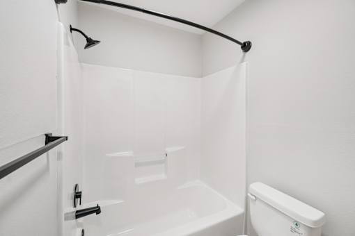 A white bathroom with a toilet, sink, and bathtub.