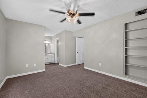 A room with a ceiling fan and a carpeted floor.