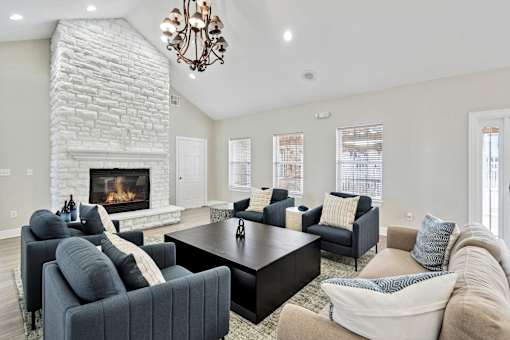 A living room with a fireplace and a chandelier.