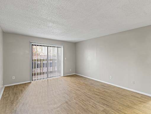 A room with a sliding door and wooden flooring.
