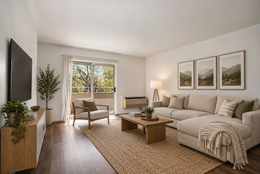A living room with a couch, chair, and a table with a plant on it.