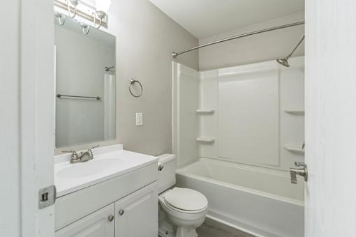 A white bathroom with a toilet, sink, and bathtub.