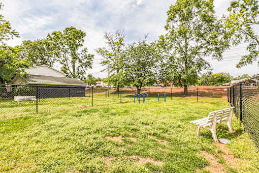A park with a baseball diamond and a fence.