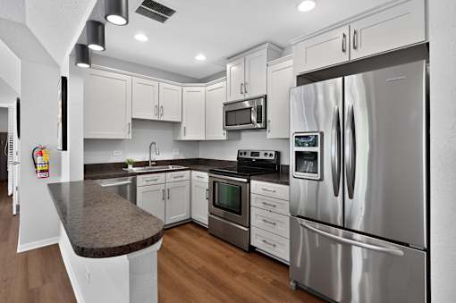 Community kitchen at Renaissance at Carol Stream featuring stainless steel appliances and white cabinets in Carol Stream, IL.