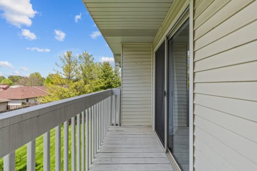 the view from the balcony of a home with white walls and a balcony door open