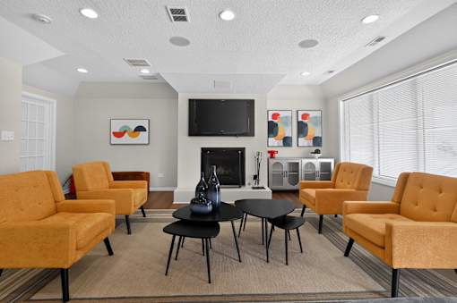 Community clubhouse at Renaissance at Carol Stream featuring seating, a fireplace, and a TV in Carol Stream, IL.