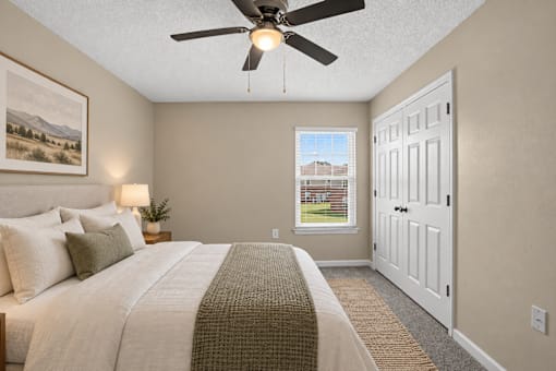 A bedroom with a large bed and a ceiling fan.