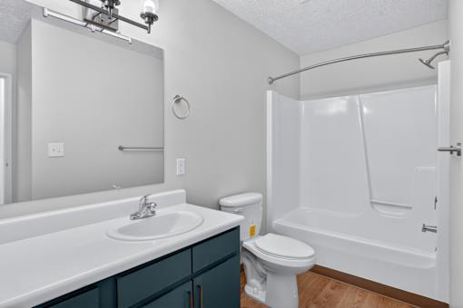A white bathroom with a white tub and a white sink.