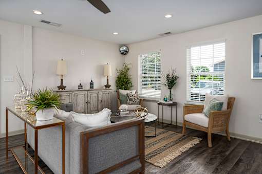 A living room with a grey couch, a wooden coffee table, and a ceiling fan.