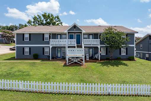 Two-story apartment with white fence at Arbours at Victoria Place Prattville AL
