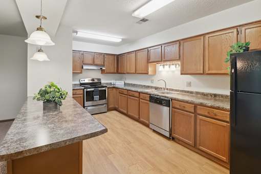 A kitchen with wooden cabinets and a black refrigerator.