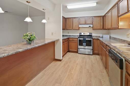A kitchen with wooden cabinets and a granite countertop.