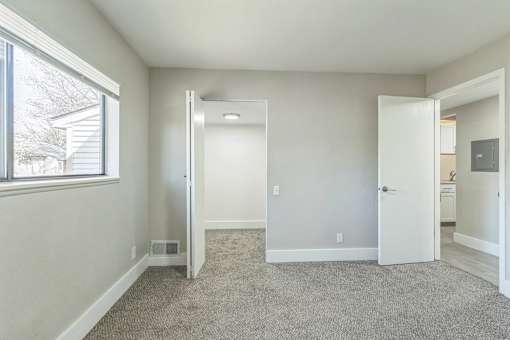 A room with a carpeted floor and a window.