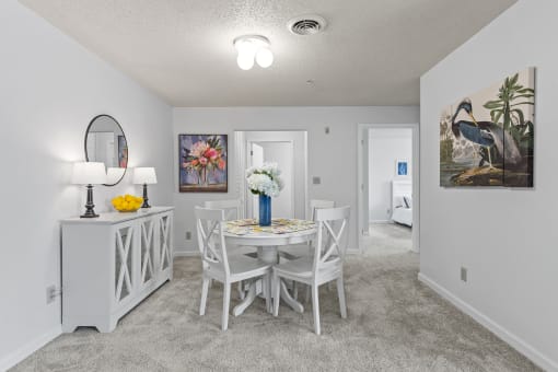 a dining room with a table and chairs and a mirror in a house