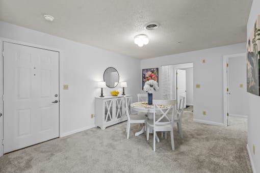 a dining room with a white table and chairs and a white door