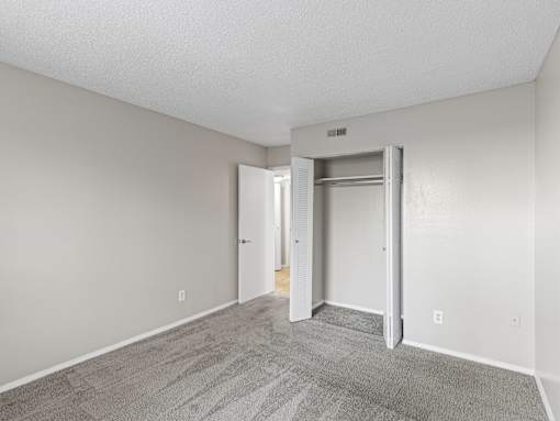 A room with a carpeted floor and a white door.