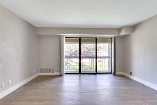A large empty room with a sliding glass door.
