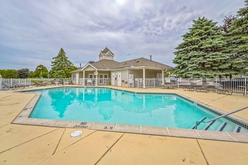 A pool with a house in the background.
