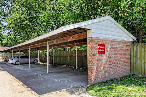 A parking garage with a red sign that says "RESERVED PARKING" is under a roof.