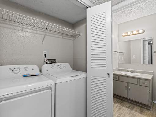 A white bathroom with a washer and dryer.
