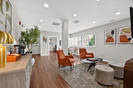 Community lounge at Renaissance at Carol Stream featuring orange chairs and a wooden floor in Carol Stream, IL.
