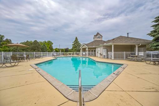 A swimming pool in a backyard with a house in the background.