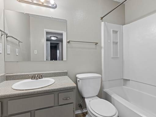 A bathroom with a toilet, sink, and bathtub.
