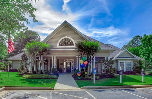 the front of a house with balloons on the lawn