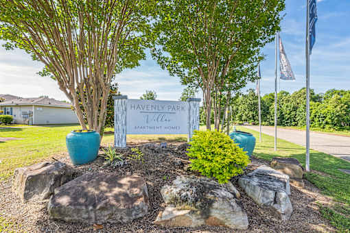 A sign that says Havenly Park in front of a tree.
