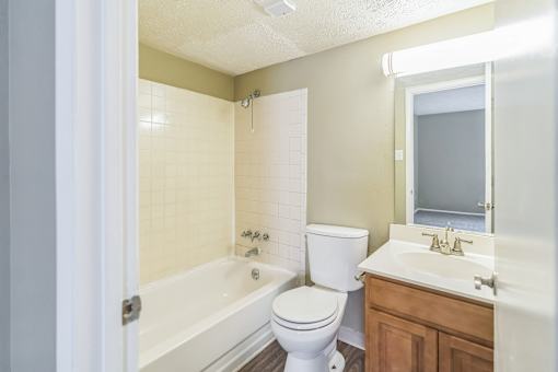 A white toilet sits next to a bathtub in a bathroom.