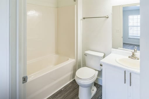 A white bathroom with a toilet, sink, and bathtub.