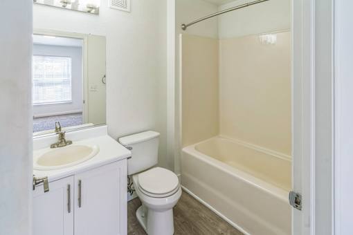 A white bathroom with a toilet, sink, and bathtub.