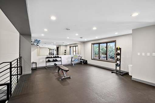 A spacious home gym with a bench, weights, and exercise equipment.