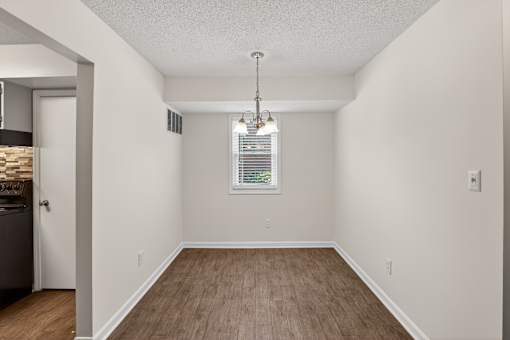 A room with wooden floors and a window with blinds.