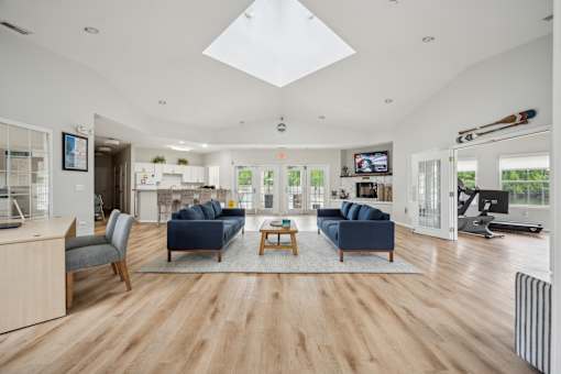 A spacious living room with a skylight and hardwood floors.