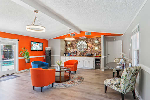 A living room with orange chairs and a white sofa.