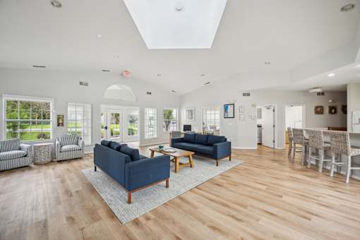 A spacious living room with a blue sofa and wooden flooring.